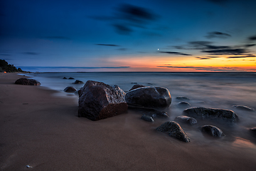 Image showing Sea sunset seascape with wet rocks