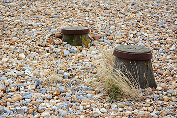 Image showing Tops of two groyne sea defences visible on a shingle beach