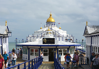 Image showing View down Eastbourne pier with tourists walking around the Victo