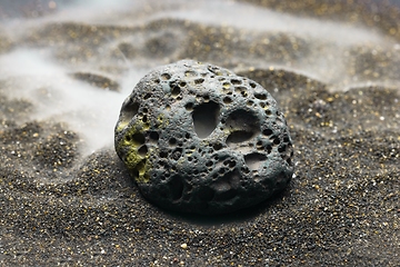 Image showing Smoke whirling around small meteorite stone