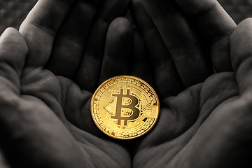 Image showing Physical bitcoin held in hands close up photo in selective colors