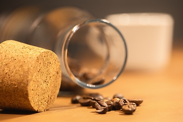 Image showing Roasted coffee beans on table with jar