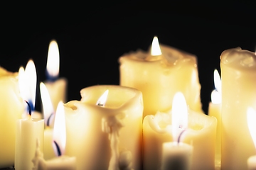 Image showing Candles glowing against dark background