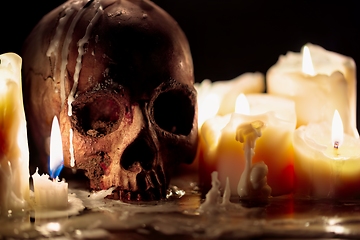 Image showing Human skull against dark background in candle light closeup