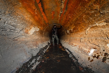 Image showing Large sewage tunnel with filth flowing out
