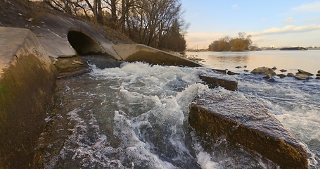 Image showing Large sewage tunnel with filth flowing out