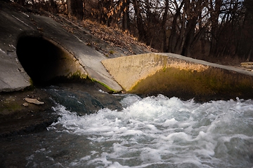 Image showing Large sewage tunnel with filth flowing out