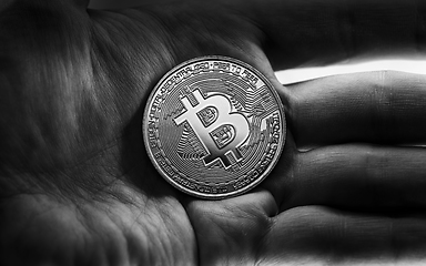 Image showing Physical bitcoin held in hands closeup in black and white