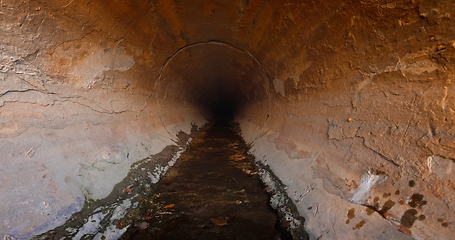 Image showing Large sewage tunnel with filth flowing out