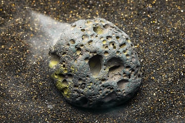 Image showing Smoke whirling around small meteorite stone