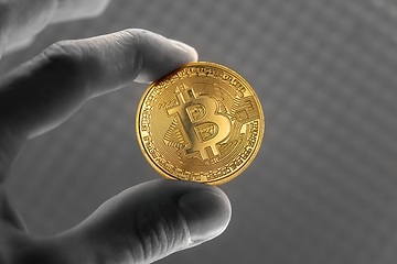 Image showing Physical bitcoin held in hands close up photo in selective colors