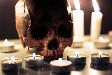 Image showing Human skull against dark background in candle light closeup