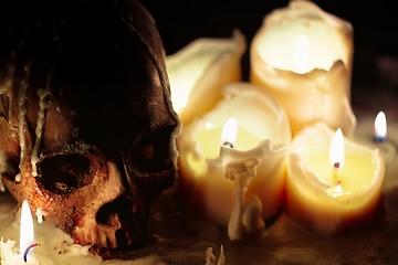 Image showing Human skull against dark background in candle light closeup