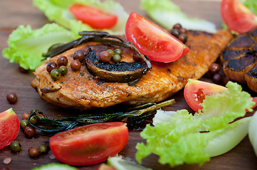 Image showing wood fired hoven cooked chicken breast on wood board 