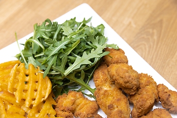 Image showing Chicken nuggets with salad on table