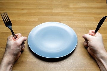 Image showing Empty dish on table with man demanding some food