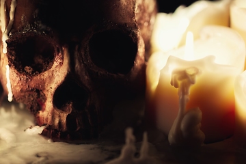 Image showing Human skull against dark background in candle light closeup