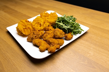 Image showing Chicken nuggets with salad on table closeup
