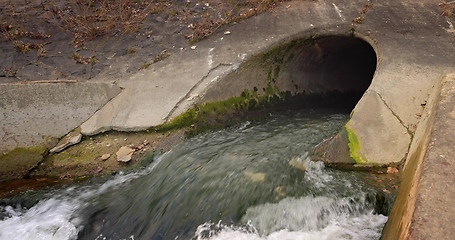 Image showing Large sewage tunnel with filth flowing out