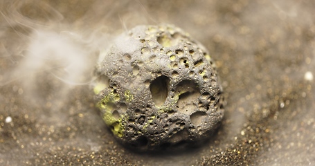 Image showing Smoke whirling around small meteorite stone