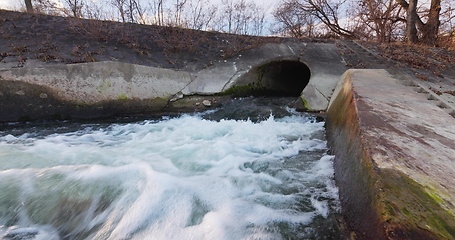 Image showing Large sewage tunnel with filth flowing out