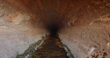 Image showing Large sewage tunnel with filth flowing out