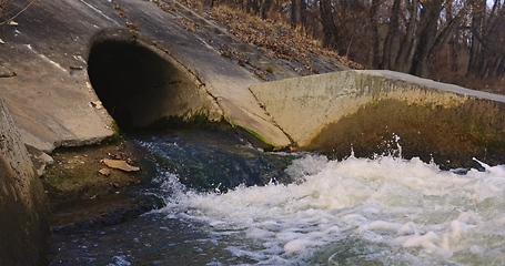 Image showing Large sewage tunnel with filth flowing out