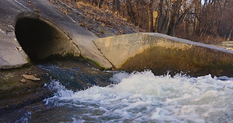 Image showing Large sewage tunnel with filth flowing out