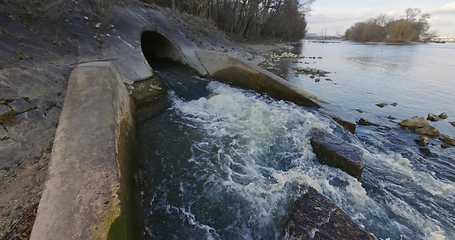 Image showing Large sewage tunnel with filth flowing out