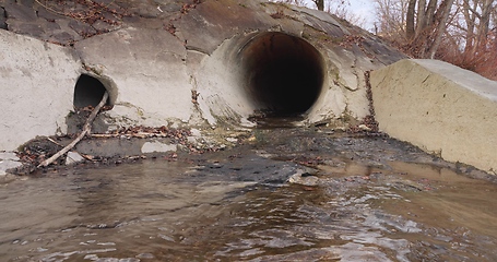 Image showing Large sewage tunnel with filth flowing out