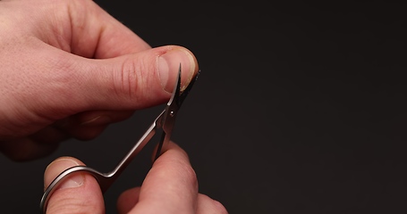 Image showing Man cuts fingernail for himself