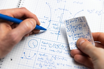 Image showing Man writing math exersize in notebook closeup