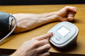Image showing Man measuring blood pressure closeup