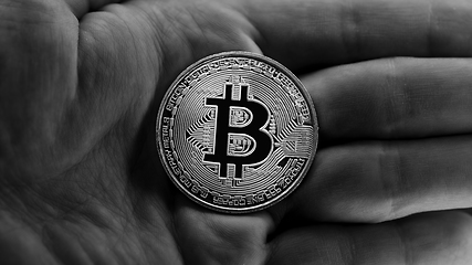 Image showing Physical bitcoin held in hands closeup in black and white