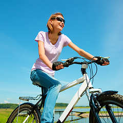 Image showing Young woman is sitting on her bicycle