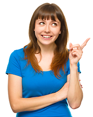 Image showing Portrait of a young woman pointing to the right