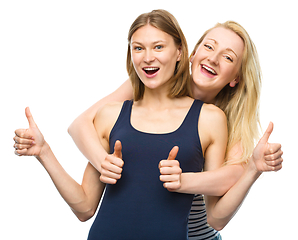 Image showing Two young happy women showing thumb up sign