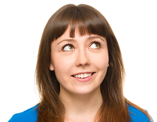 Image showing Young happy woman is looking up and smile