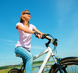 Image showing Young woman is sitting on her bicycle