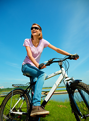 Image showing Young woman is sitting on her bicycle