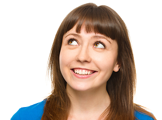 Image showing Young happy woman is looking up and smile