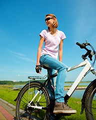 Image showing Young woman is sitting on her bicycle