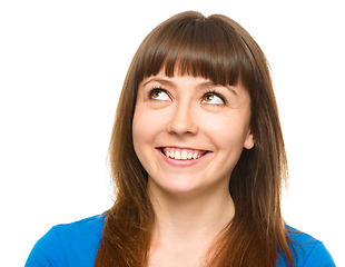 Image showing Young happy woman is looking up and smile