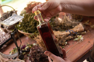 Image showing potion bottle in hand of herbalist