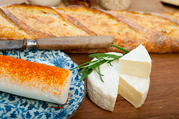 Image showing French cheese and fresh  baguette on a wood cutter