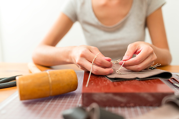 Image showing Woman making bag with leather