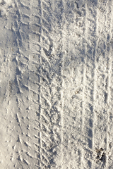 Image showing the imprint of the car wheels on snow close-up