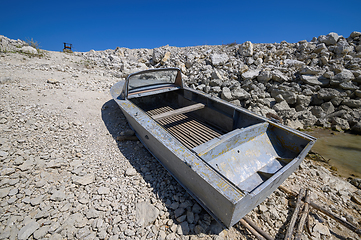 Image showing Empty old metal fishing motor boat at shore