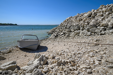 Image showing Empty old metal fishing motor boat at shore