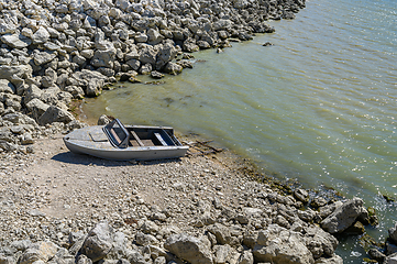 Image showing Empty old metal fishing motor boat at shore